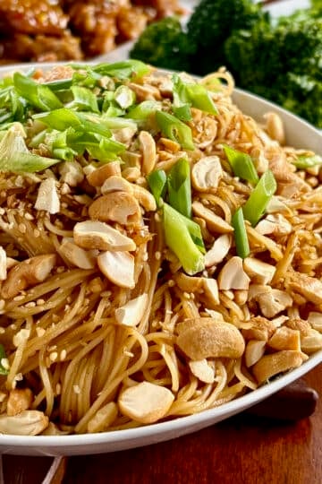 Sesame Garlic Noodles with Cashews photo of on noodles in a white serving bowl for featured image.