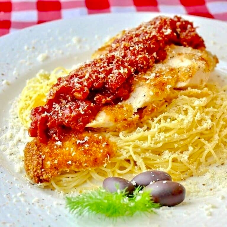 Low Fat Baked Panko Chicken Parmesan plated on a bed of spaghetti
