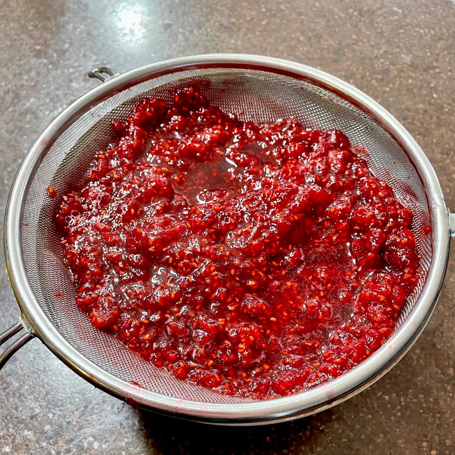 Photo if the cooked berries draining in a sieve.