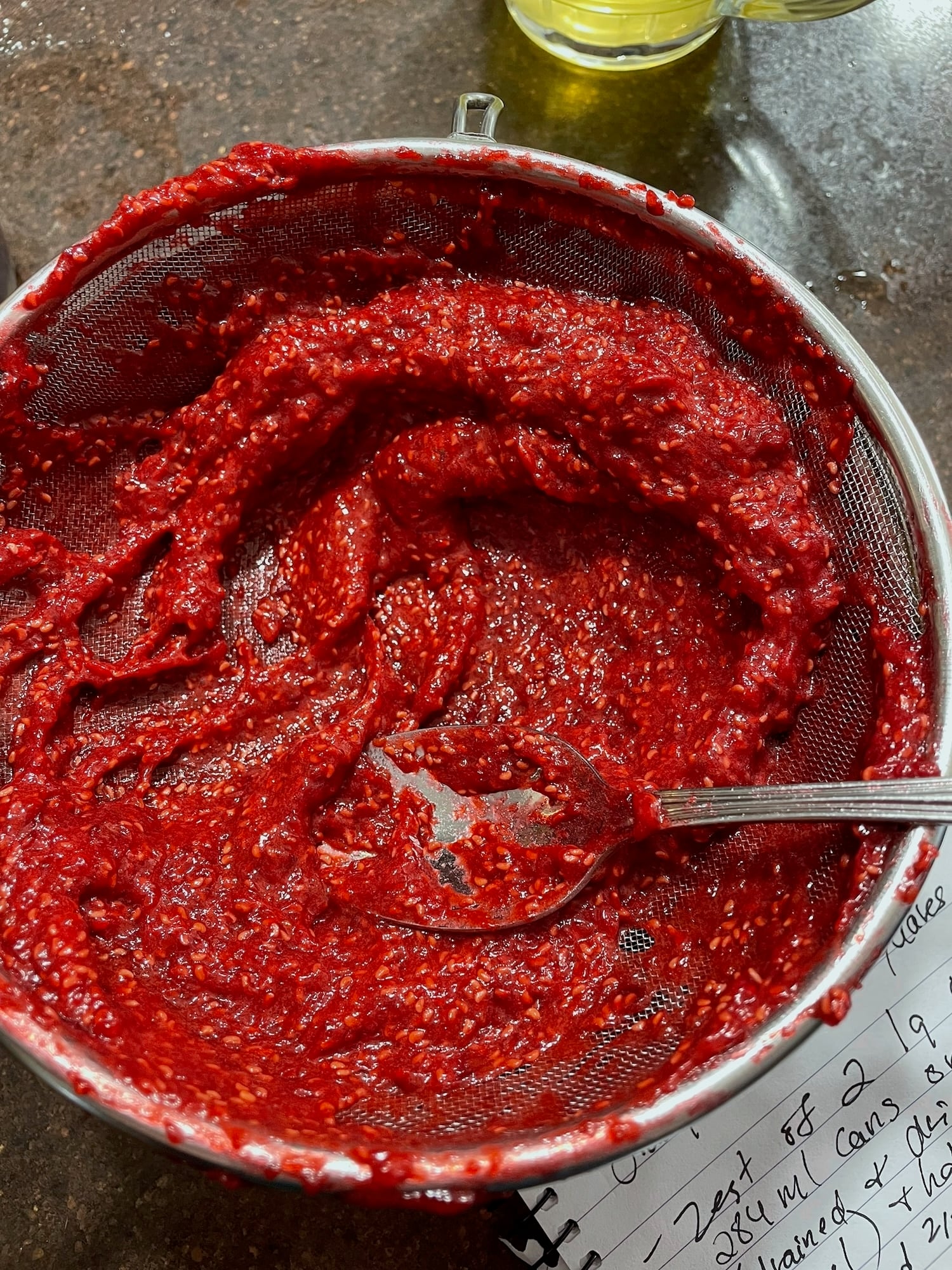 Photo if Pressing the berries through the sieve leaving the seeds behind.