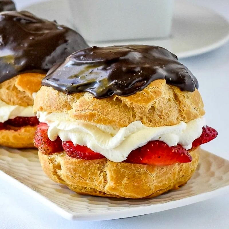 Strawberry Chocolate Custard Cream Puffs close up featured image of cream puffs on a platter,