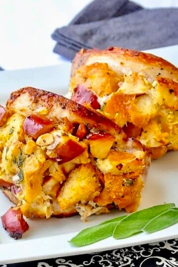 Apple Almond Sage Stuffed Pork Chops on a white plate with sage garnish.