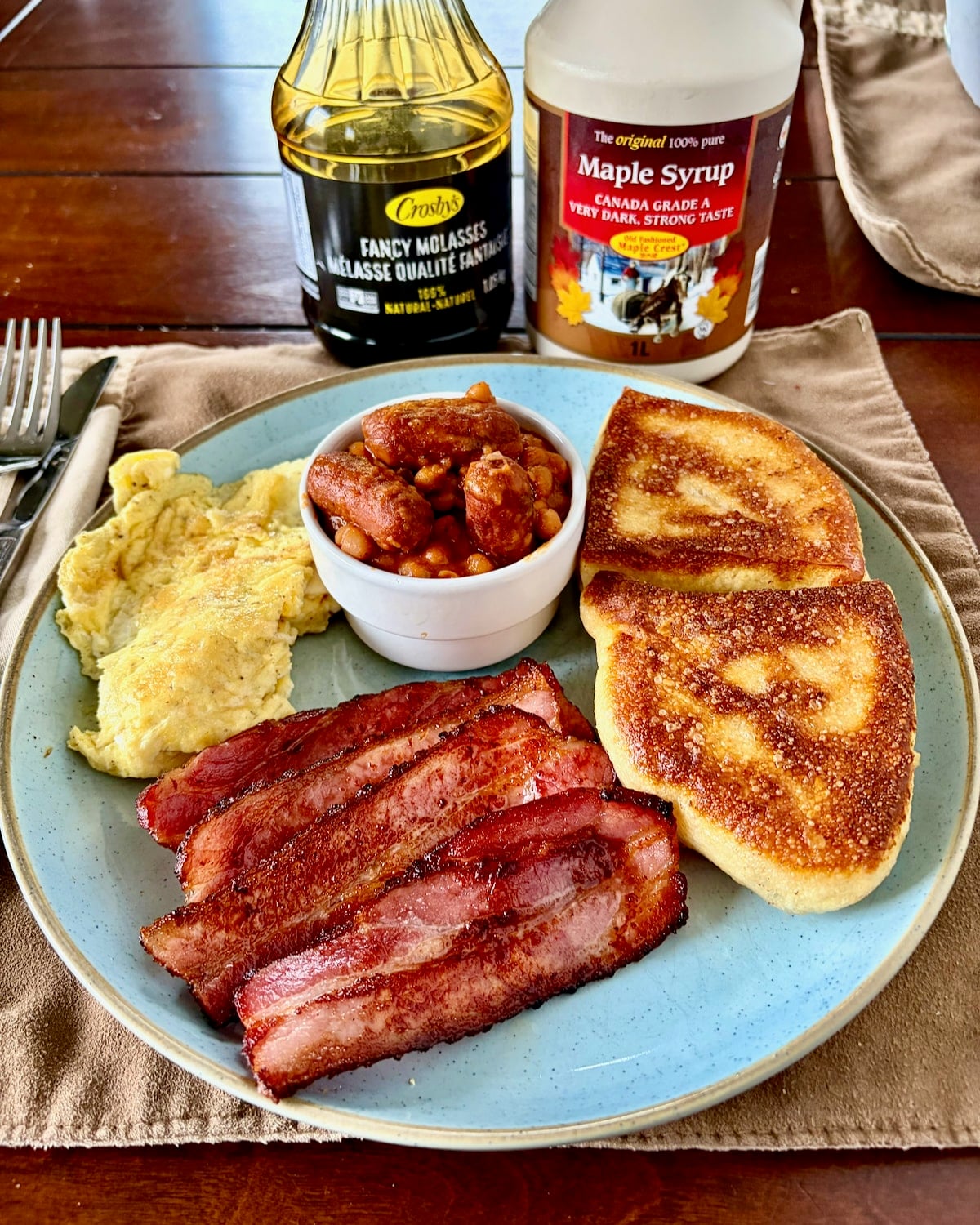 Photo of a Newfoundland breakfast featuring beans and wieners, scrambled eggs ,toutons and homemade bacon
