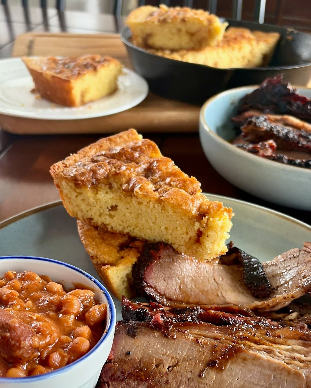 Photo of Sweet Brown Sugar Skillet Cornbread pictured with a smoked brisket dinner.
