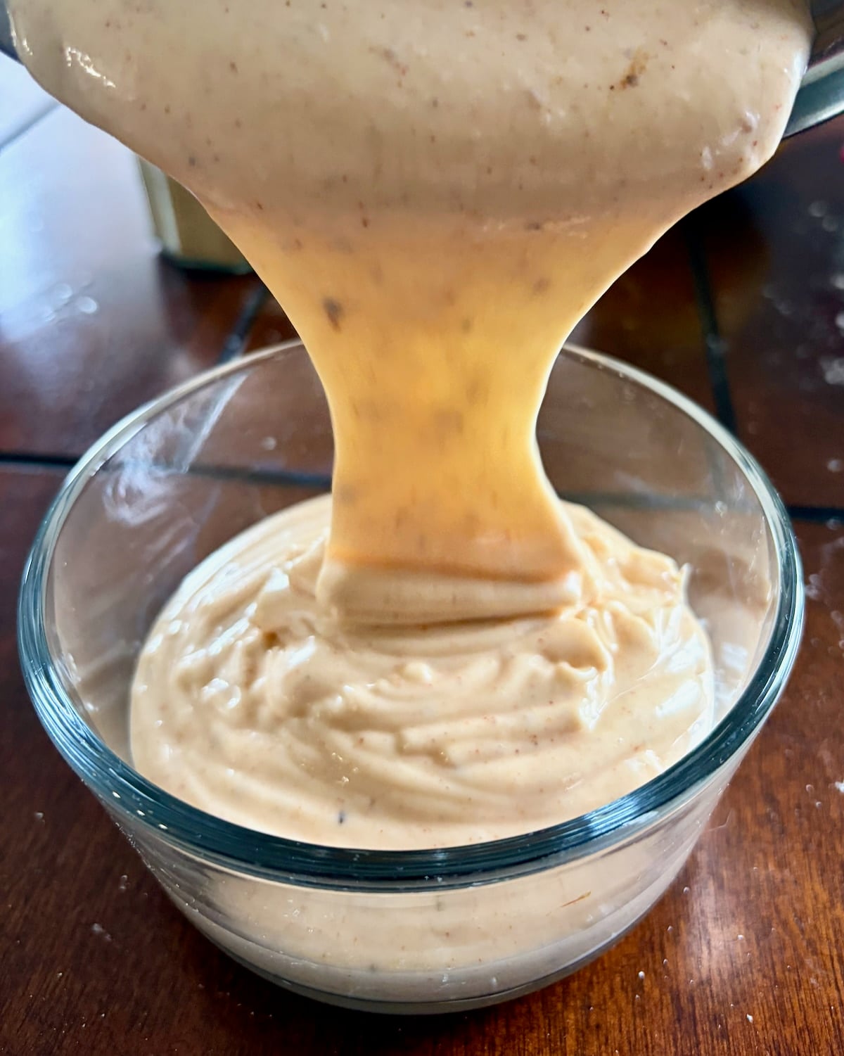 Photo of better than Miracle Whip salad dressing being poured into a glass bowl.