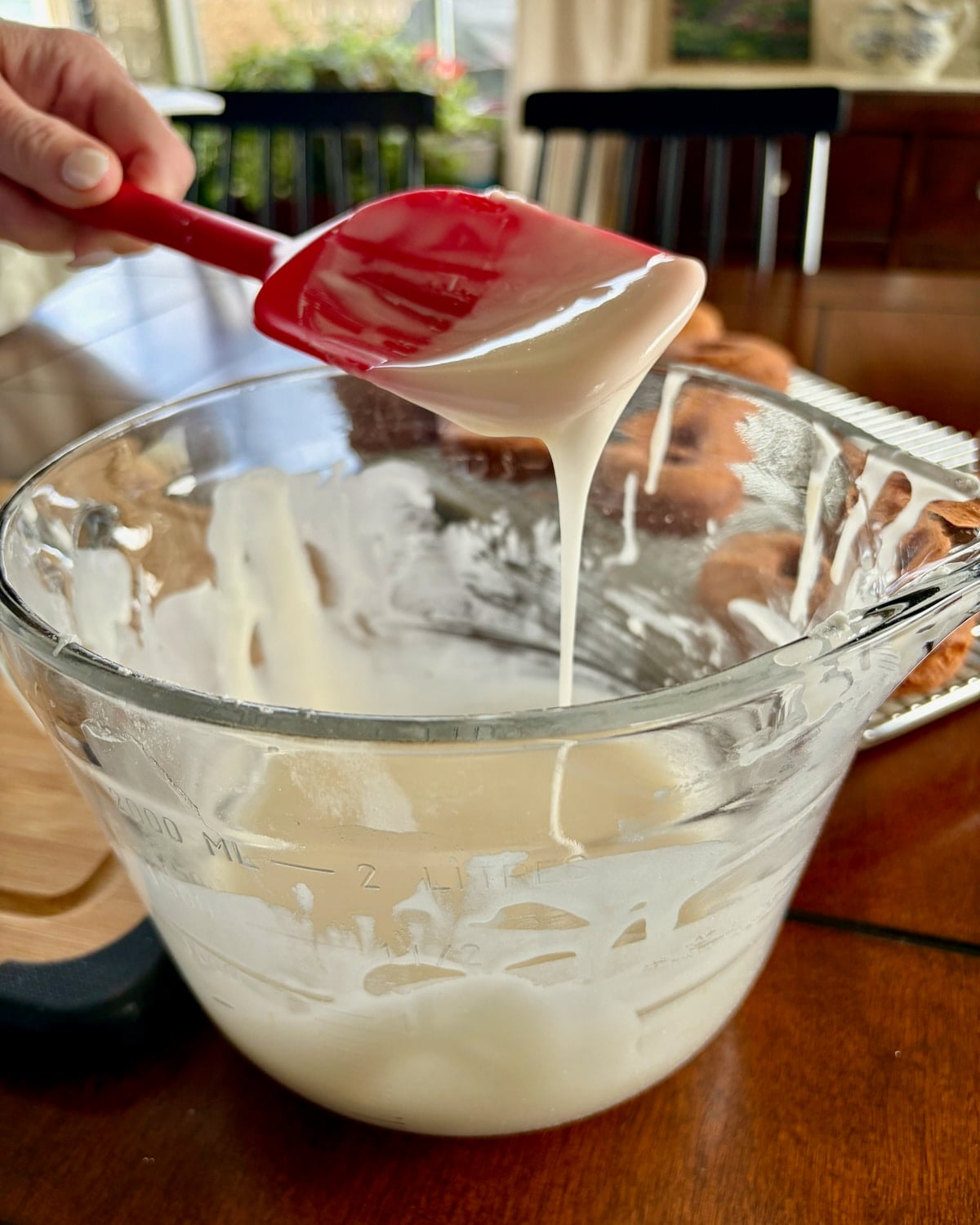 Photo of the proper consistency of vanilla glaze for sour cream donuts.