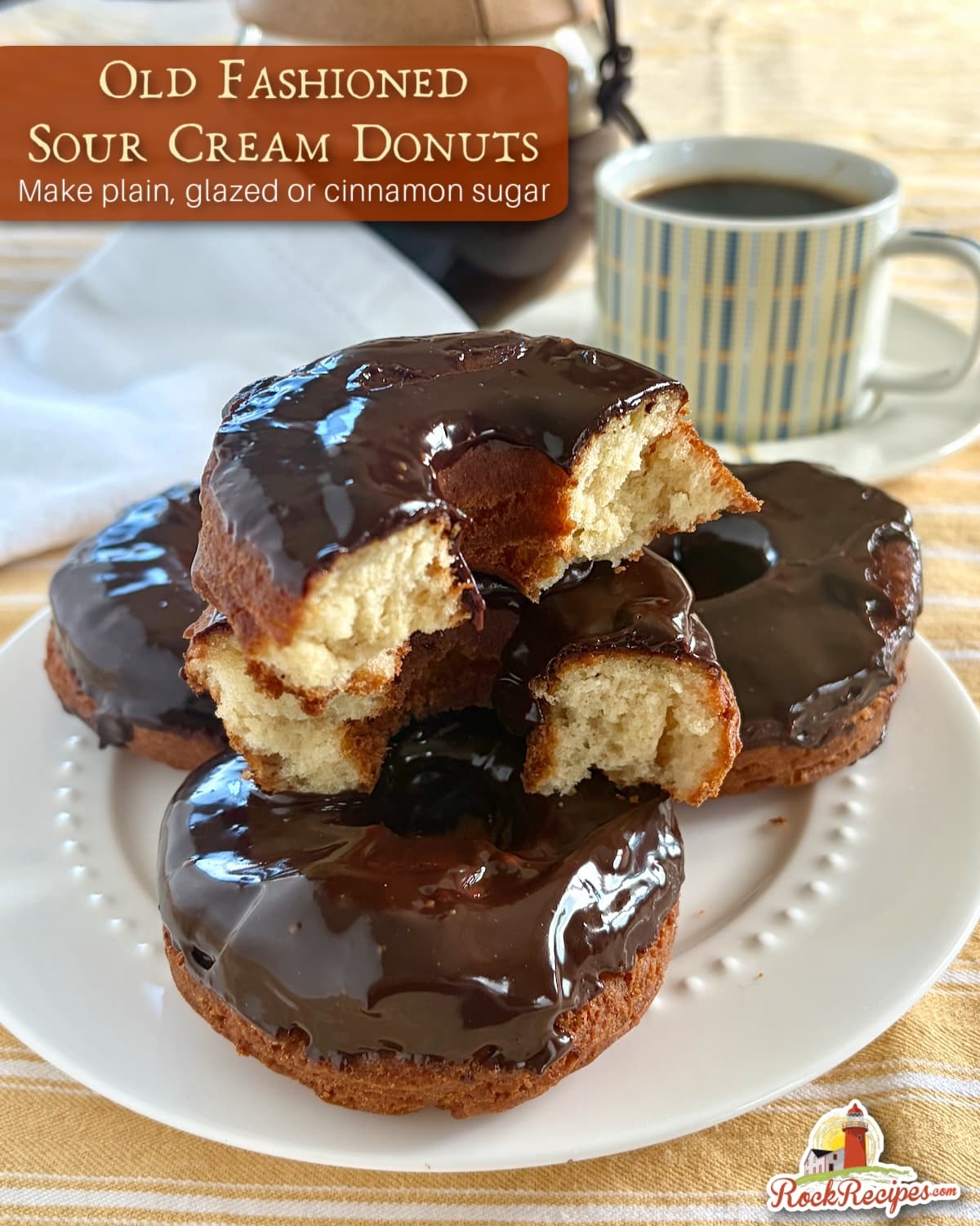 Photo of stacked chocolate glazed sour cream donuts with title text and rock recipes logo added for Pinterest and social media posts.
