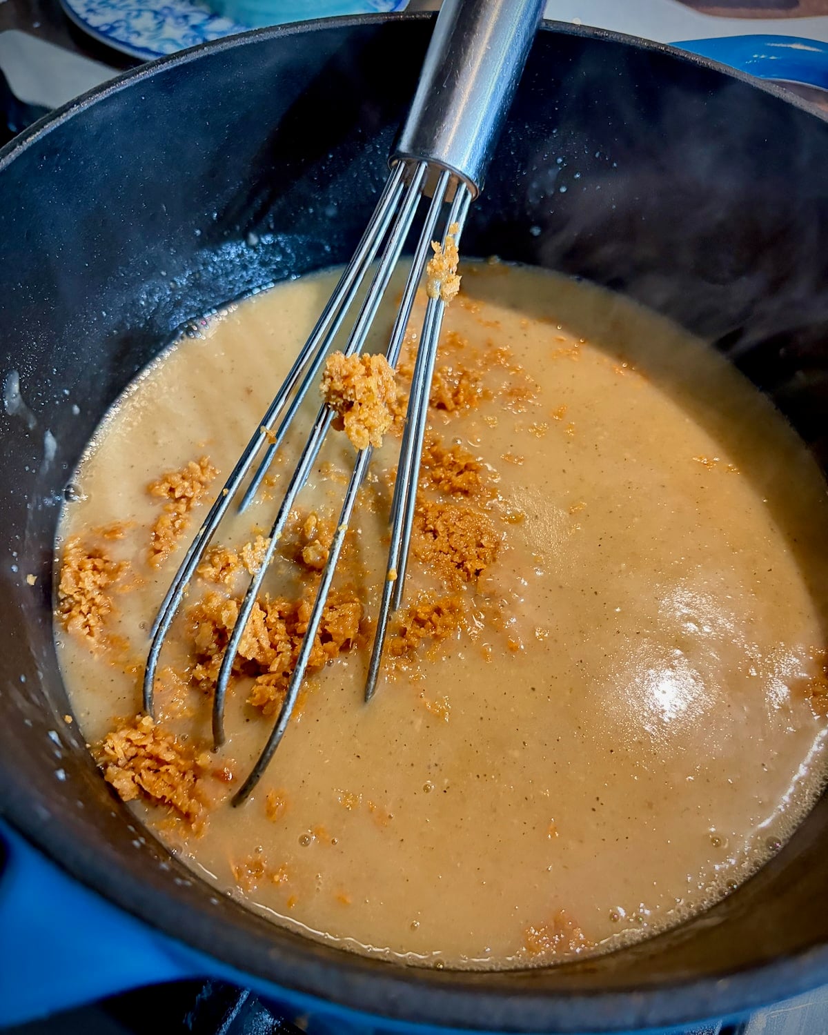 Adding the crispy chicken skins to the gravy