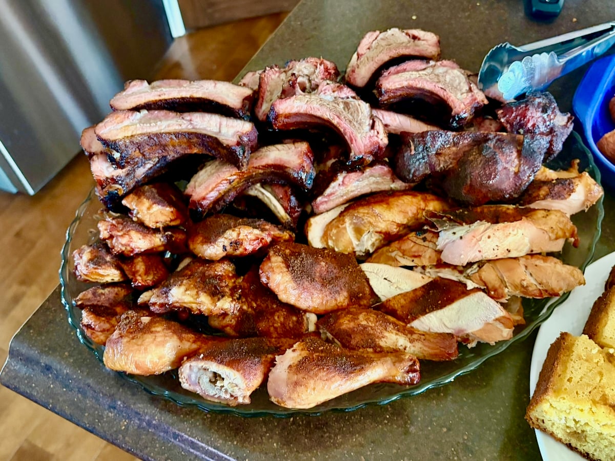 Photo of smoked pork back ribs and smoked chicken caught in pieces on a platter