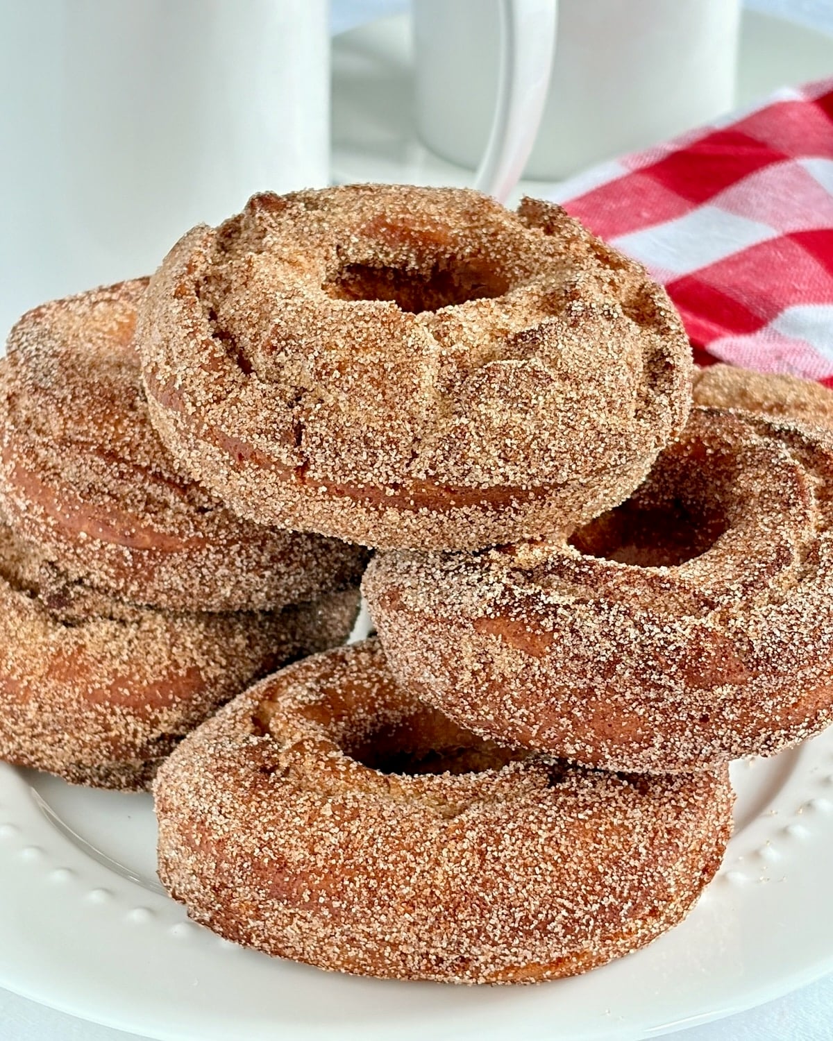 Close up of cinnamon sugar donuts on a white plate.