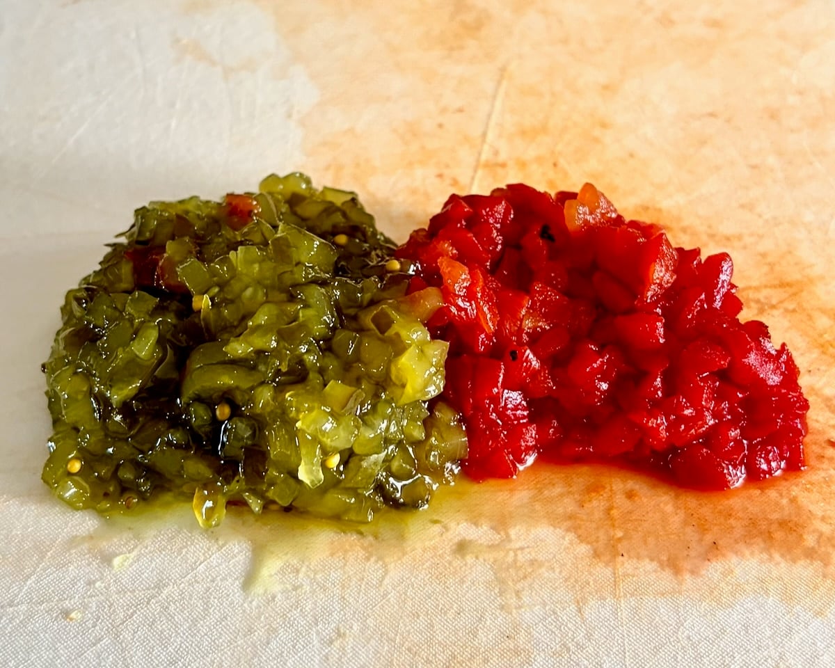 Photo of sweet relish and chopped pimento on a white cutting board