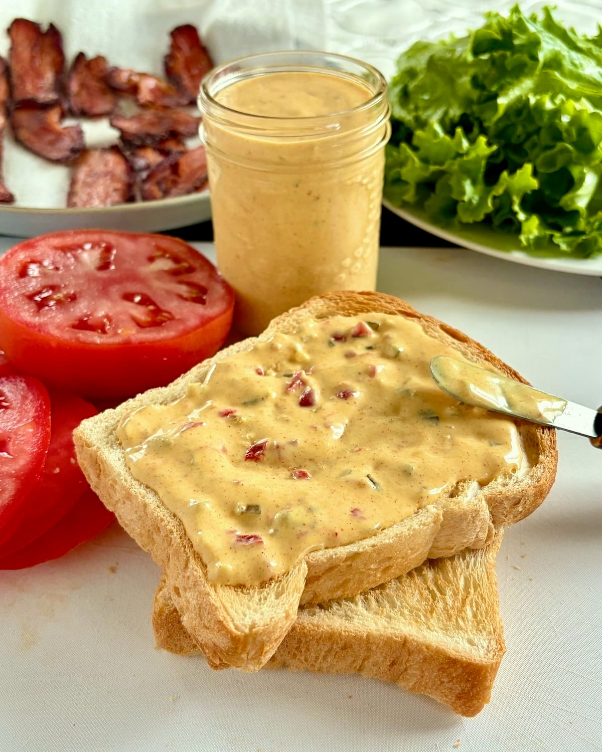Photo of sandwich bread being added to a BLT sandwich