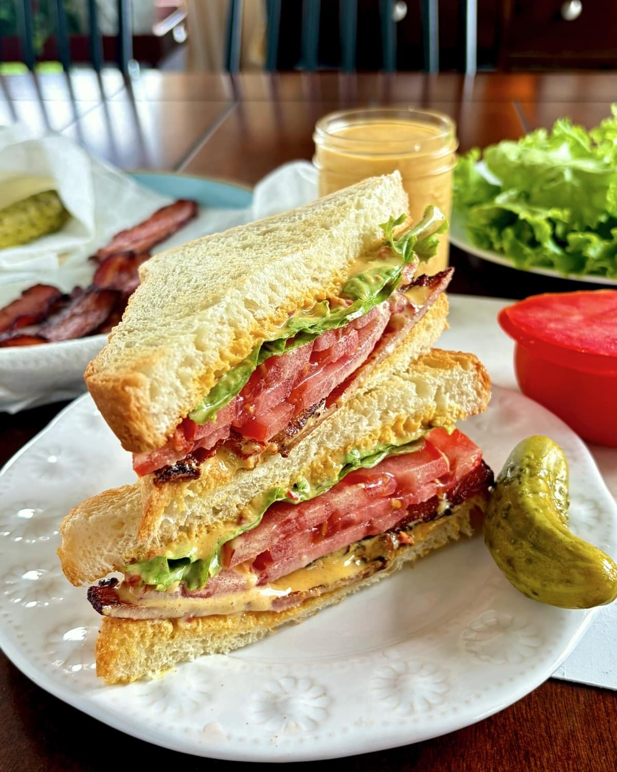 Photo of a BLT sandwich caught and stacked on a white plate