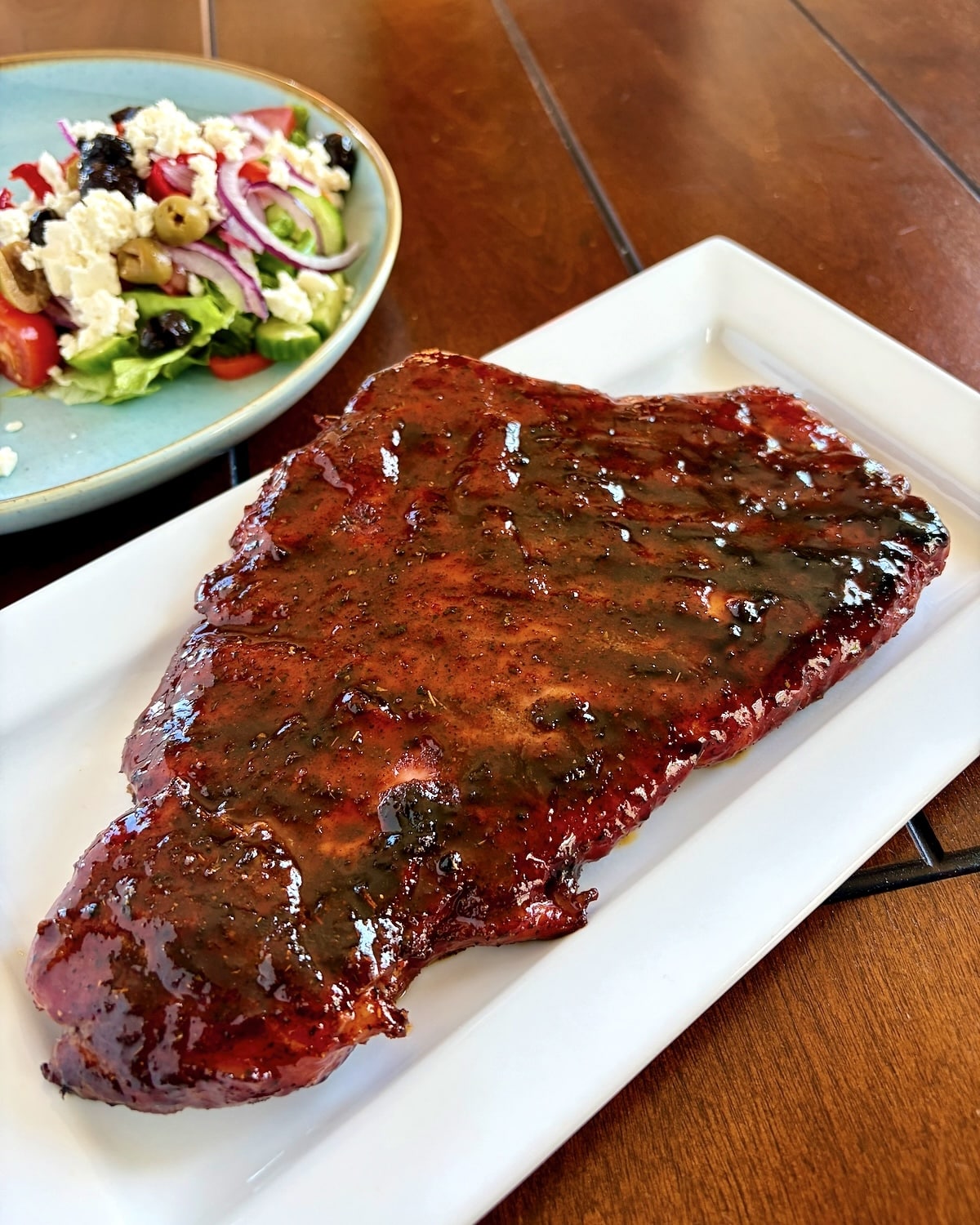 Barbecue Boneless Ribs photo of entire rack of ribs before slicing on a white serving platter, square cropped photo for Google Featured image