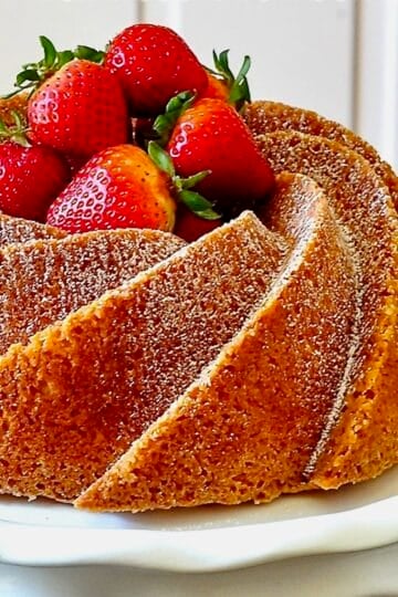 close up photo of Orange Bundt Cake on a white pedestal stand for Google featured image.