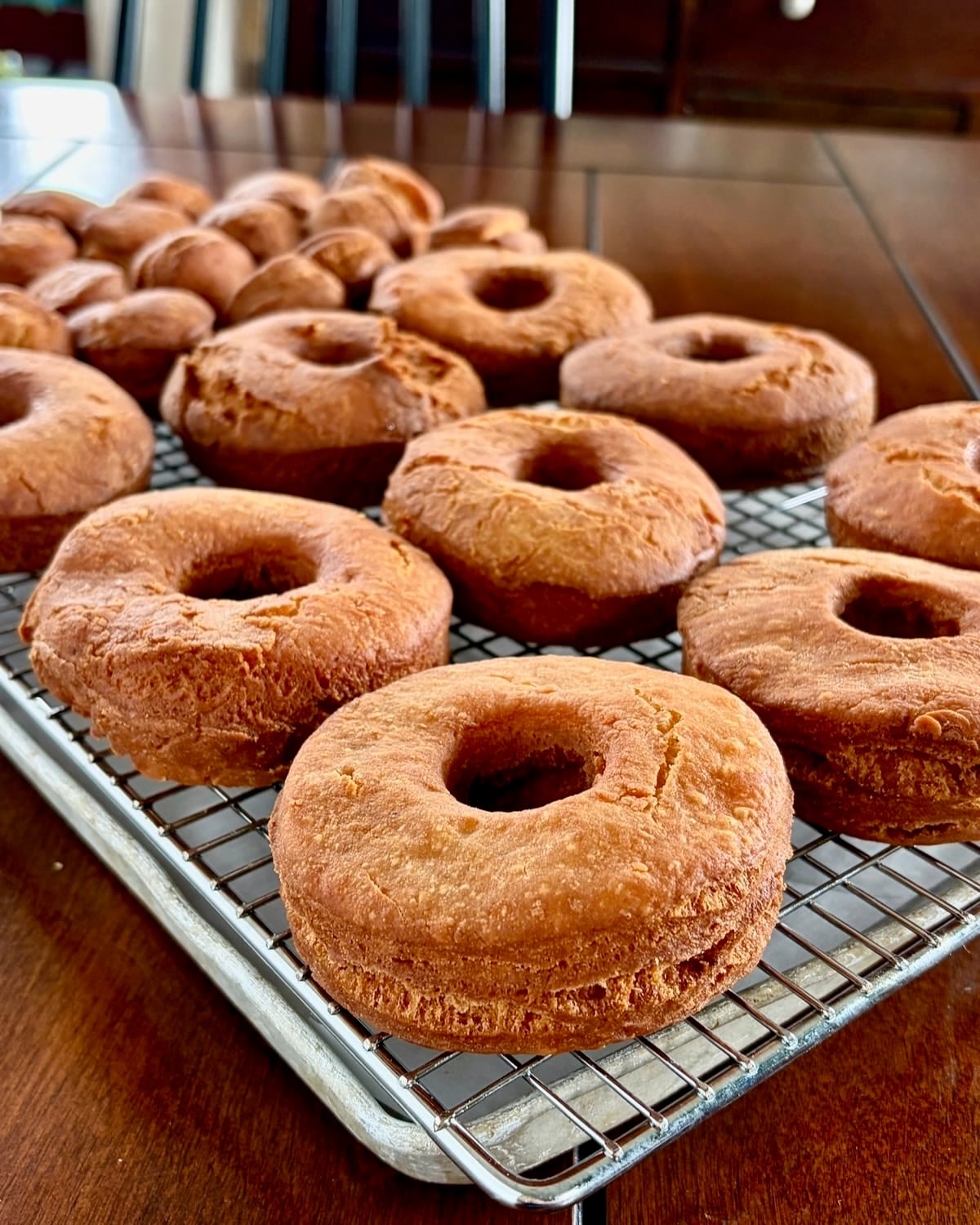 Photo of fried sour cream donuts cooling on a wire rack