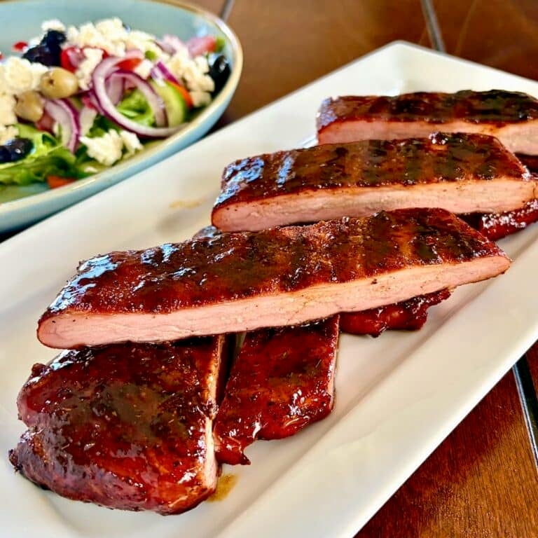Barbecue Boneless Ribs sliced and stacked n a white serving platter, square cropped photo for Google Featured image