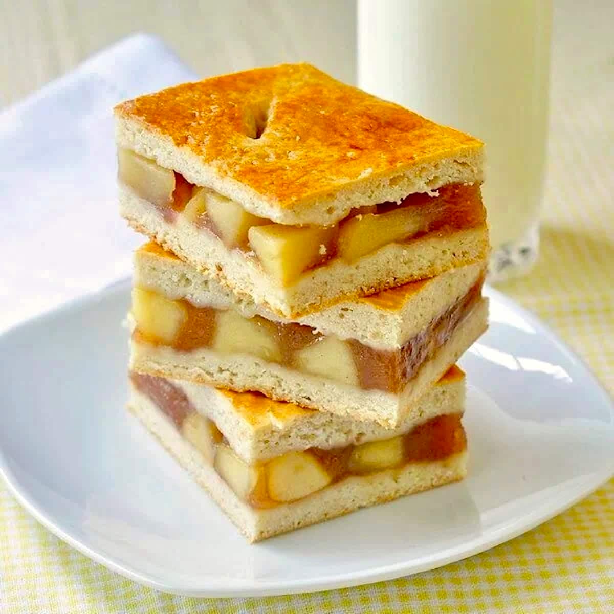 Apple Cobbler Bars stacked on a white plate.