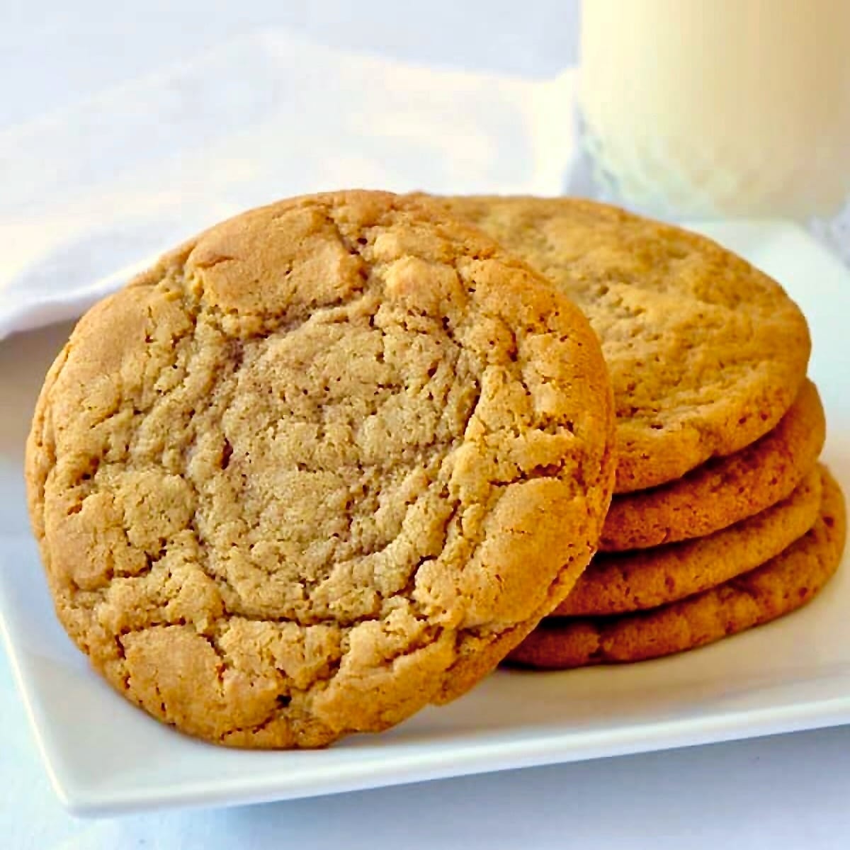 Photo of Brown Butter Cookies on a white plate with a glass of milk.
