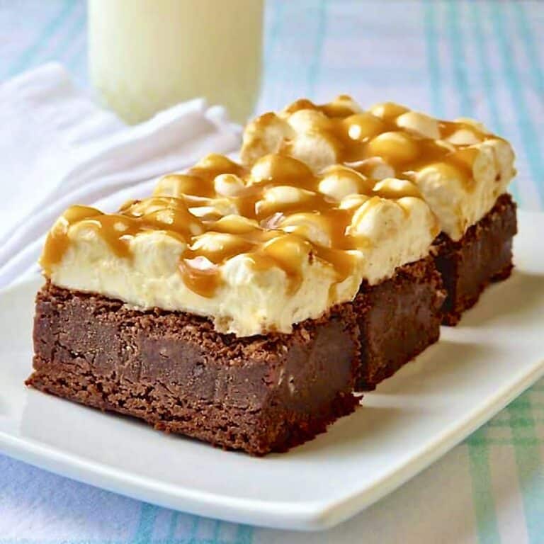 Caramel Marshmallow Brownies shown on a white plate with a glass of milk in the background.