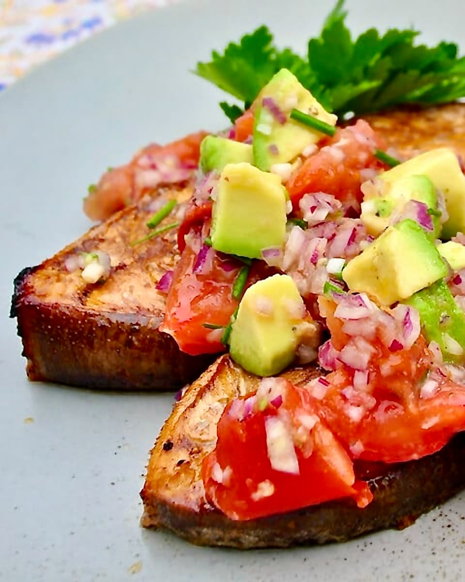 Cedar Plank Halibut with Charred Tomato Avocado Salsa shown on a light blue serving platter.