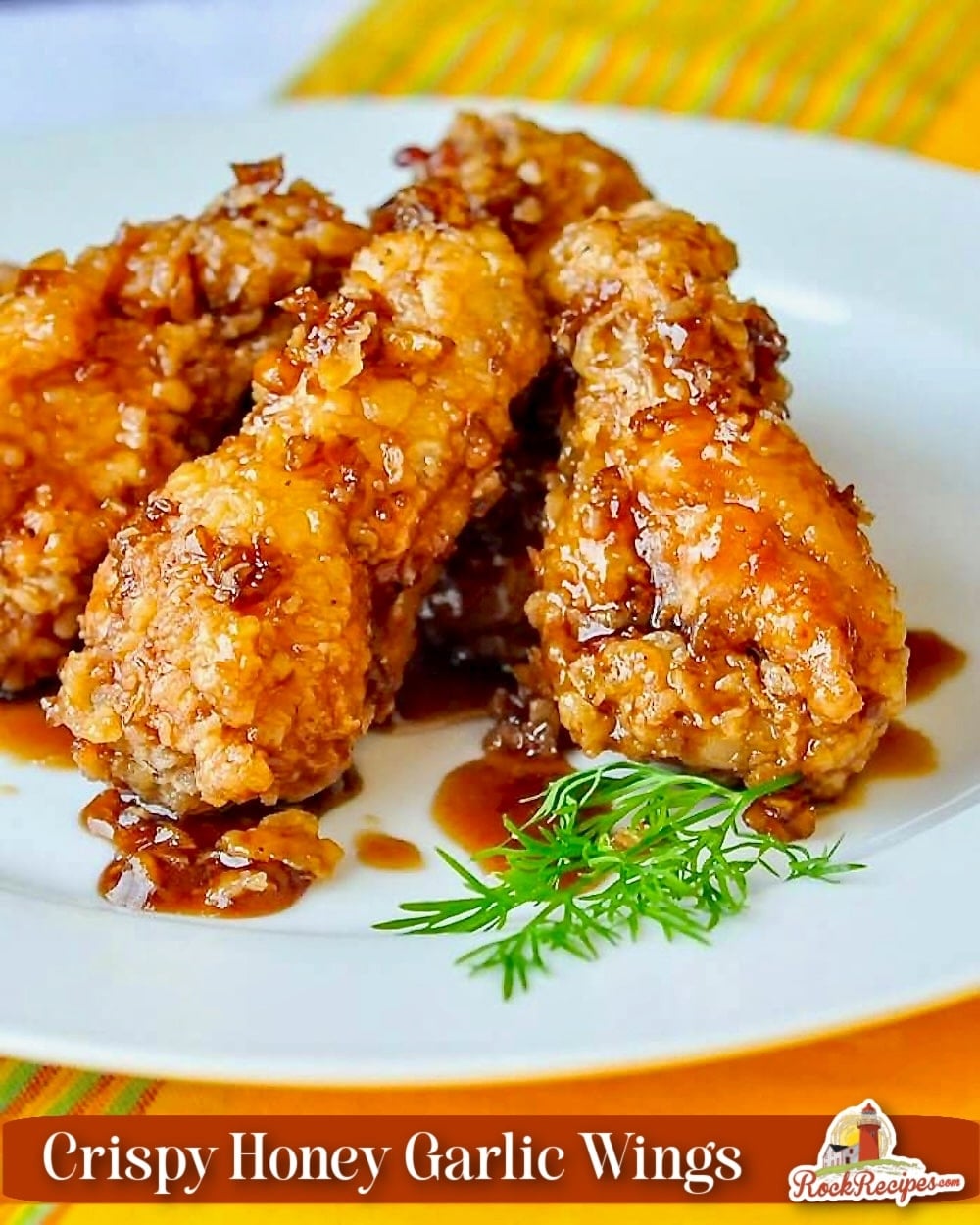 Crispy Honey Garlic Chicken Wings close up photo on a white plate with title text added for Pinterest and social media posts.