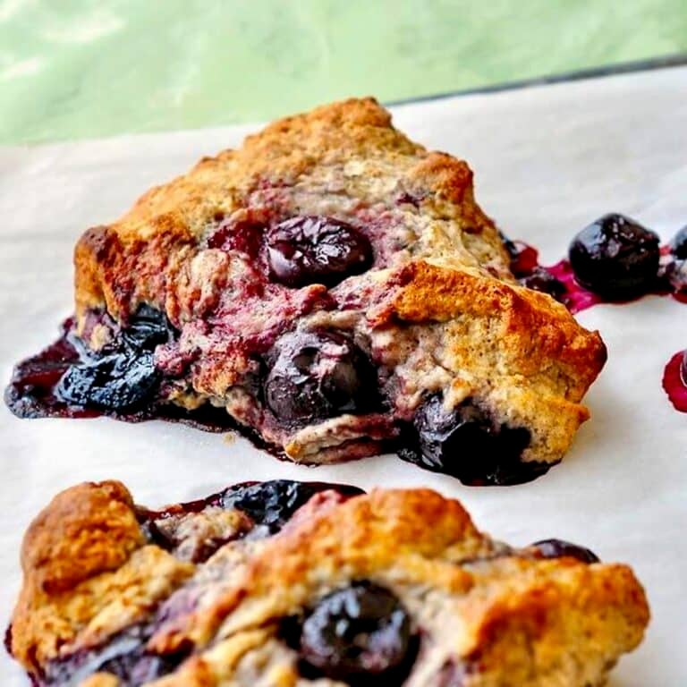 Cherry Spice Scones shown cooling in a parchment paper lined baking pan.
