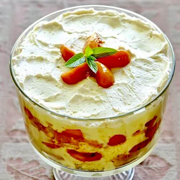 Peaches and Cream Trifle in a clear glass trifle bowl pedestal stand.
