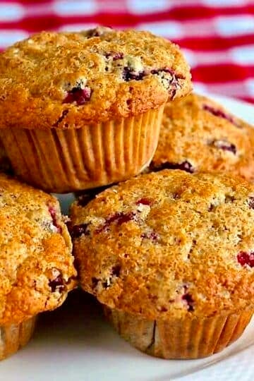 Photo of Cranberry Flax Muffins stacked on a white plate FOR GOOGLE FEATURED IMAGE..
