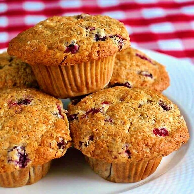 Photo of Cranberry Flax Muffins stacked on a white plate FOR GOOGLE FEATURED IMAGE..