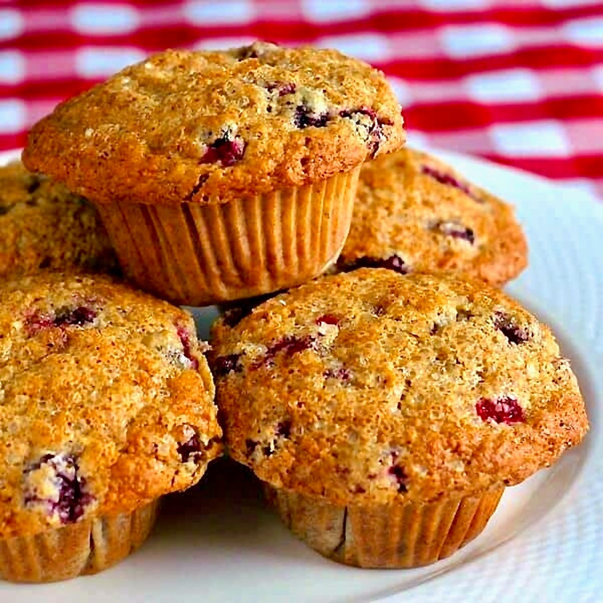 Photo of Cranberry Flax Muffins stacked on a white plate FOR GOOGLE FEATURED IMAGE..