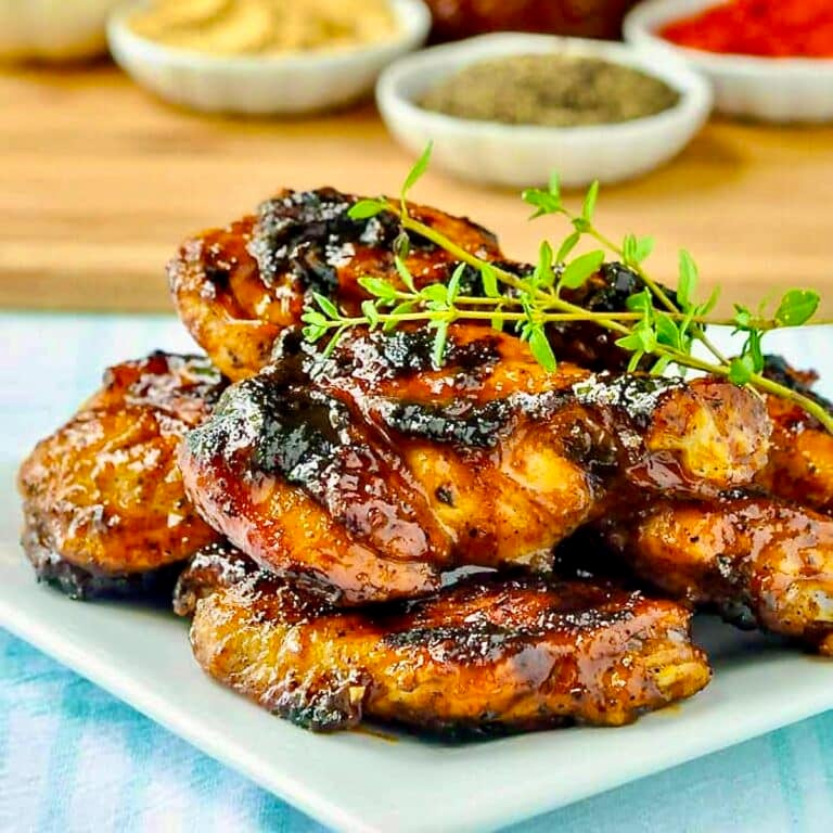 Honey Peach Barbecue Sauce on Grilled Wings close up photo of wings stacked in a white plate.