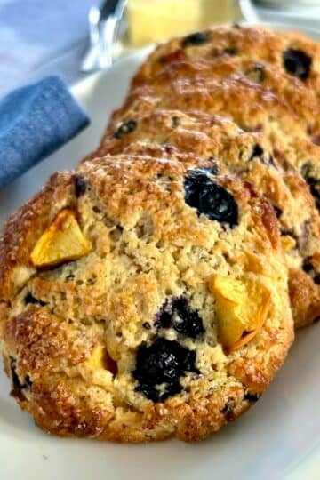 Blueberry Peach Coconut Scones close up photo of scones on a white plate.