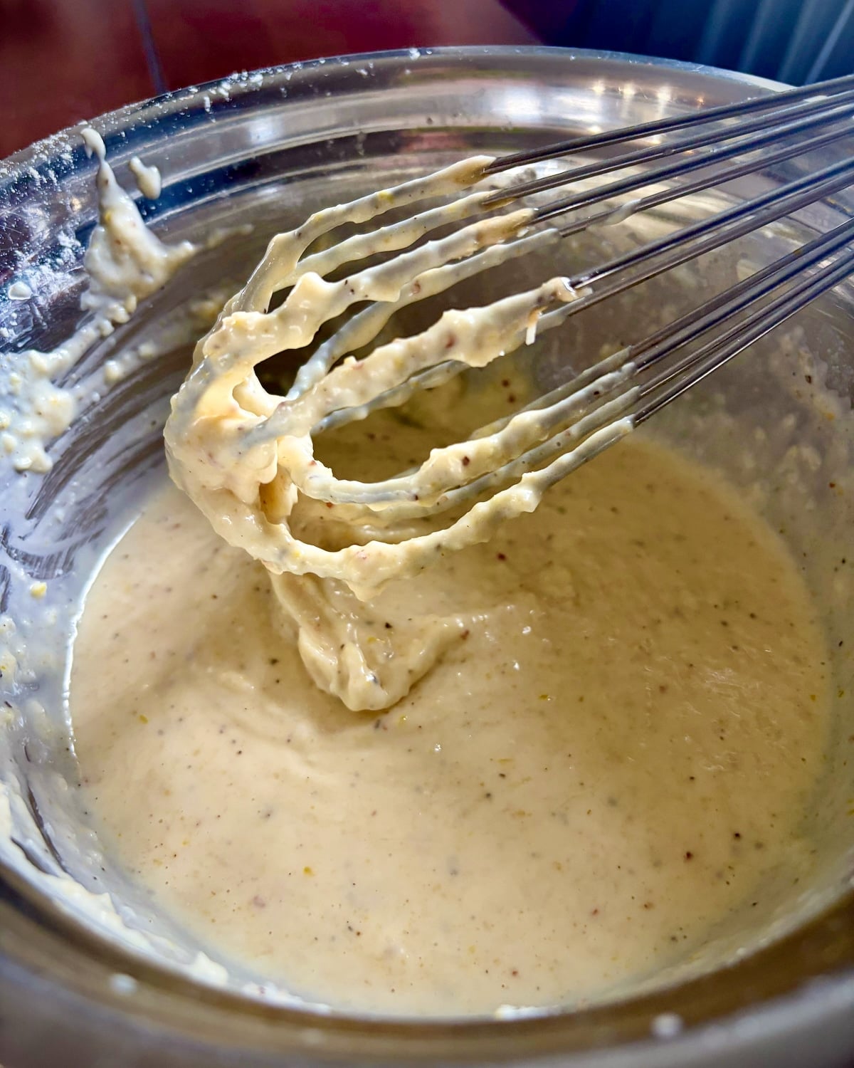 Photo of all of the ingredients for Creamy Lemon Parmesan Salad Dressing being whisked together.