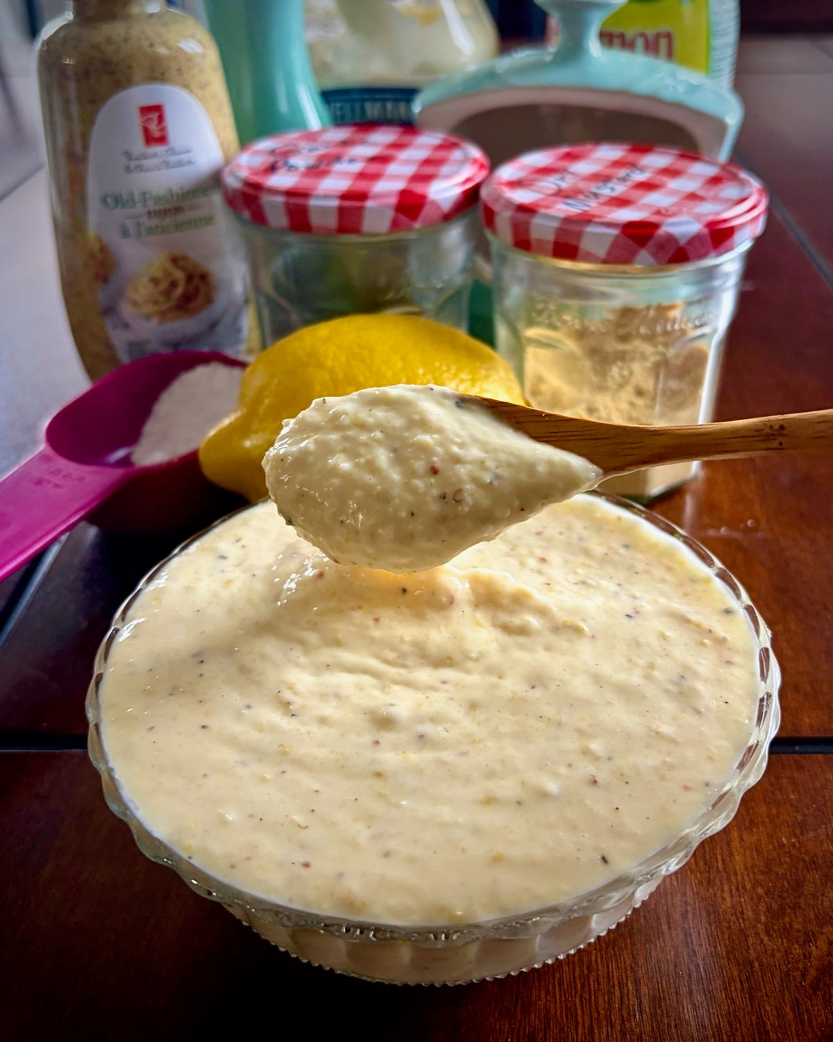 Photo of a wooden spoon dipping into Creamy Lemon Parmesan Salad Dressing