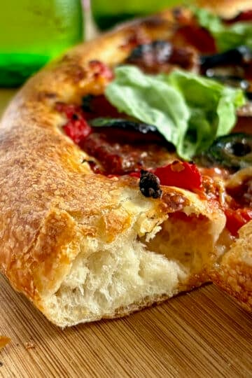 Authentic Neapolitan Pizza Dough close up photo of sliced pizza to show the inside of the crust edges.