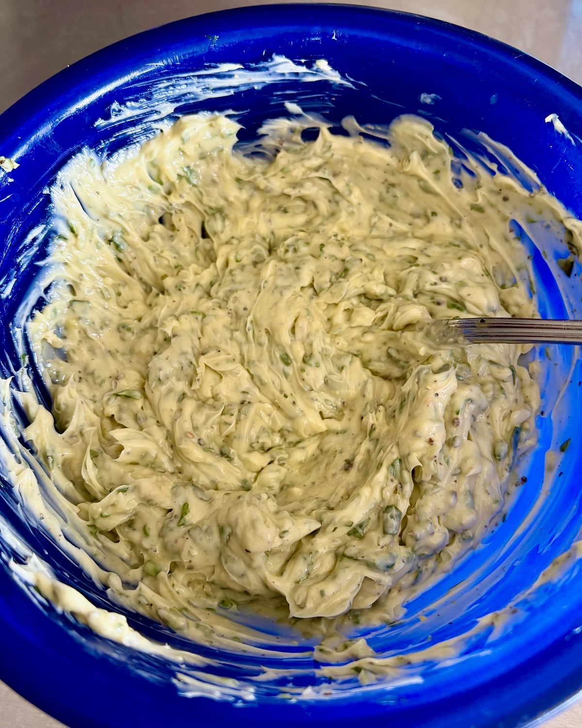 Photo of smooth completed butter in a blue mixing bowl.