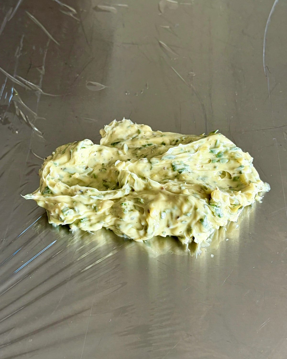 Photo of Garlic Herb Butter on a sheet of plastic wrap.