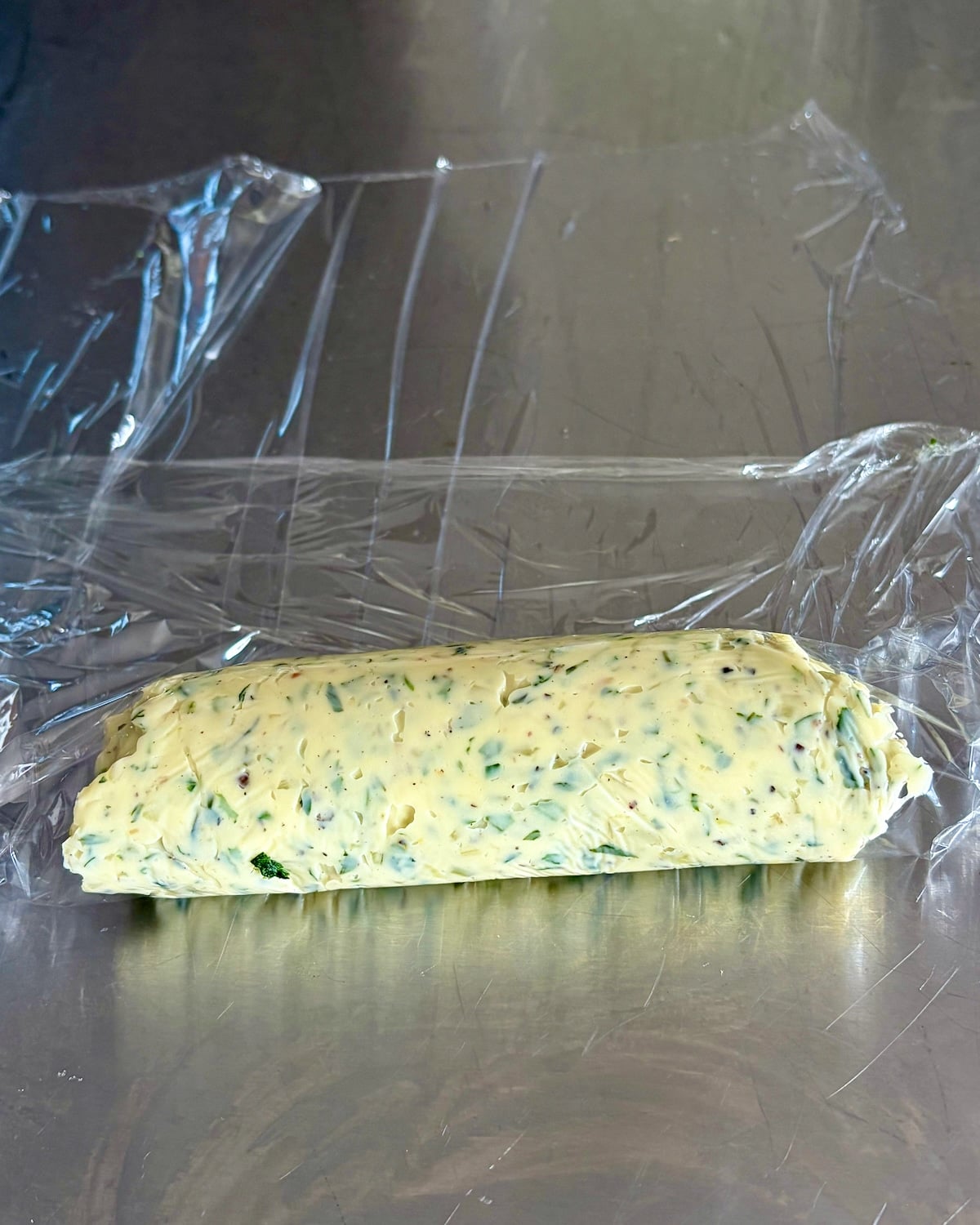 Photo of a log of Garlic Herb Butter being rolled.