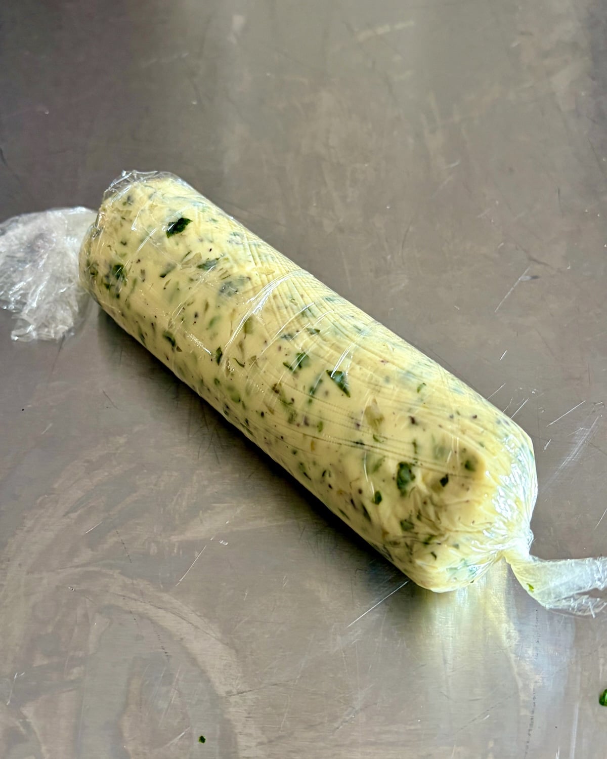 photo of a completely rolled and wrapped log of Garlic Herb Butter.