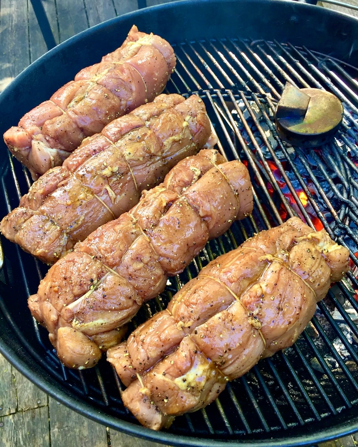 Photo of 4 Homemade Tenderloin Ham in a charcoal smoker.