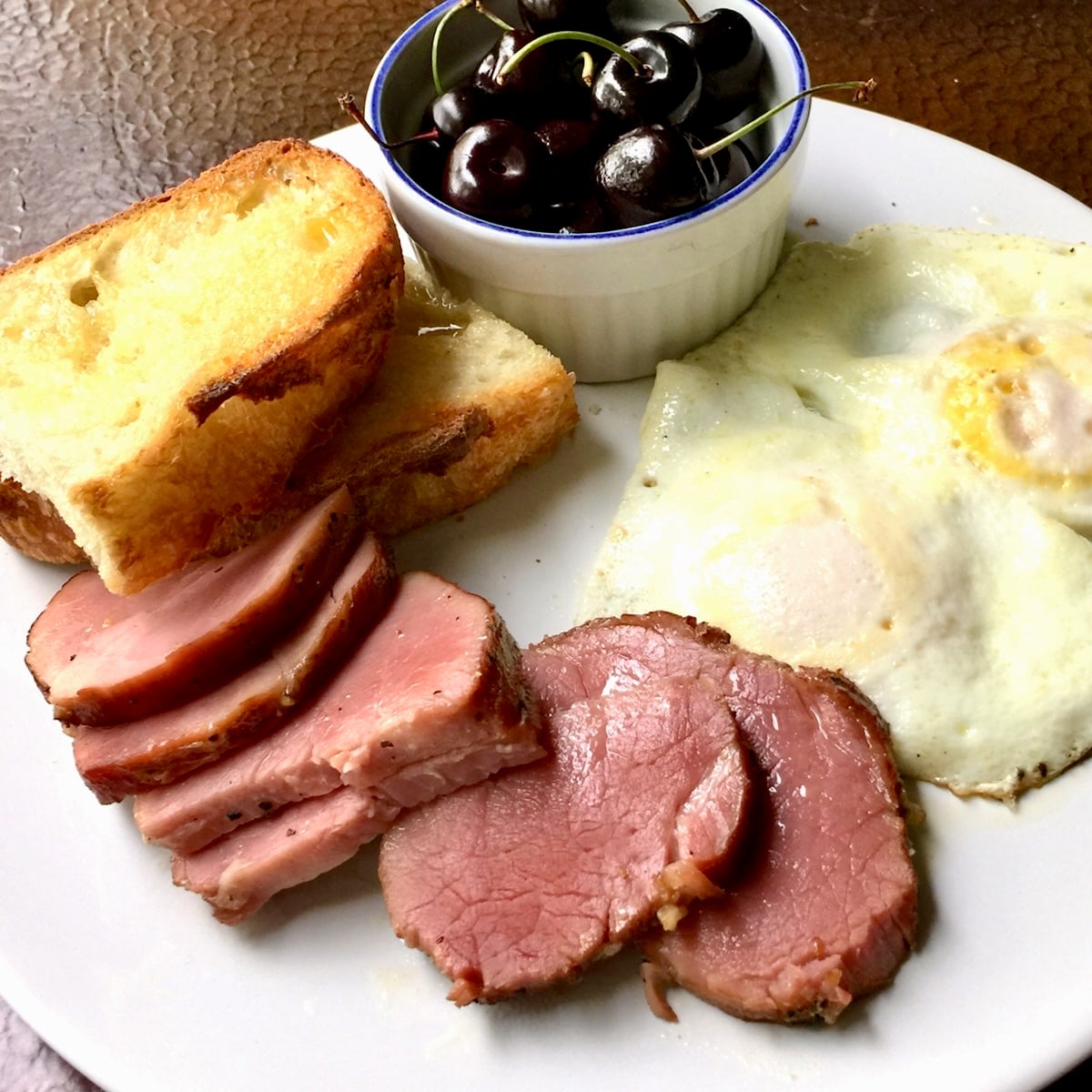 Photo of Homemade Tenderloin Ham lightly fried on a breakfast plate.