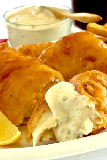Photo of Lime Caper Tartar Sauce drizzled over a piece of battered cod.