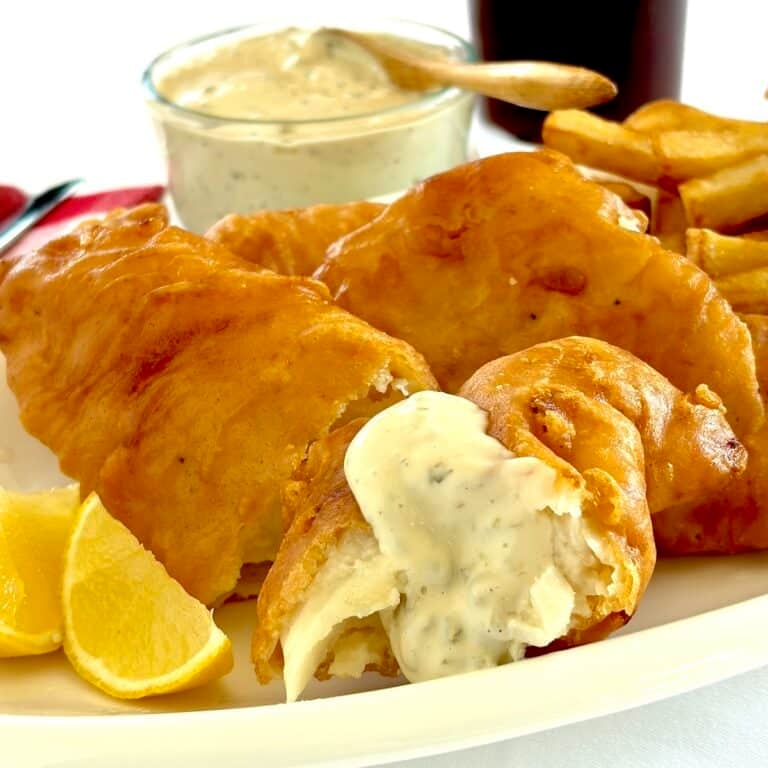 Photo of Lime Caper Tartar Sauce drizzled over a piece of battered cod.