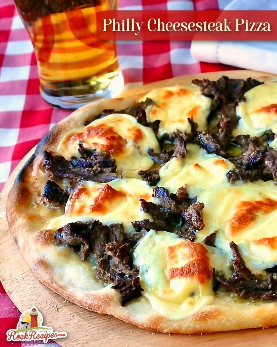 Philly Cheesesteak Pizza shown uncut in a wooden pizza peel with title text added for social media and Pinterest posts.