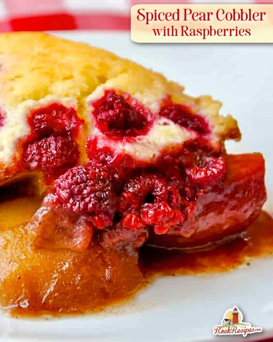 Spiced Pear Cobbler with Raspberries close up photo of one serving in a white plate with title text added for social media posts.