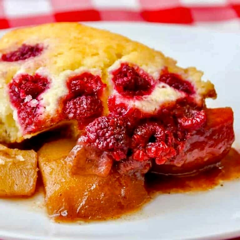 Spiced Pear Cobbler with Raspberries close up photo of one serving in a white plate