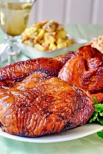 Simple Brined Smoked Turkey close up featured photo of finished turkey with side dishes in the background.