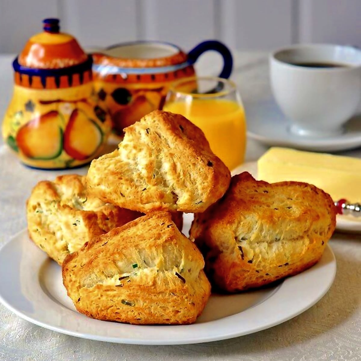 Buttermilk Chive Biscuits shown with tea service in the background.