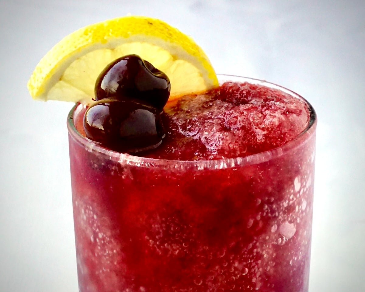Cherry Vodka Slush close up photo with lemon wedge